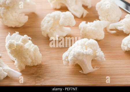 Produits frais bio Chou-fleur, coupé en petits morceaux sur fond de bois. Banque D'Images