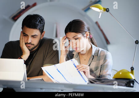 Jeune couple examen des factures et faire famille plan d'affaires. Notion d'argent et économique majeur pour l'homme et la femme qui vivent ensemble Banque D'Images