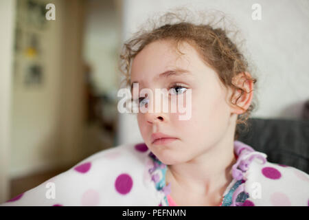 Portrait d'un curly haired fillette de six ans en pleine réflexion Banque D'Images