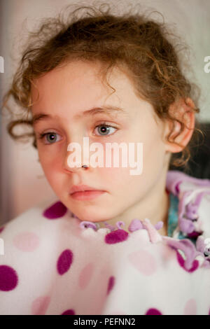 Portrait d'un curly haired fillette de six ans en pleine réflexion Banque D'Images