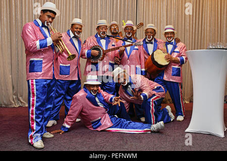 Ménestrels Kaapse Klopse habillés de couleurs vives, et la lecture d'un tableau d'instruments de musique Banque D'Images