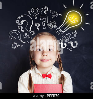 Curious kid d'âge scolaire avec lightbulb et craie d'interrogation. Faites un remue-méninges et idée concept Banque D'Images