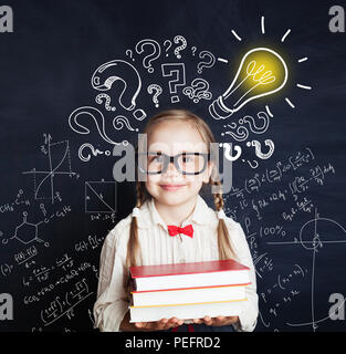 Élève de l'école élémentaire avec fille fière expression montrant ses idées sur la tête. Kid holding books Banque D'Images