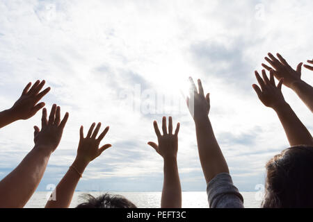 De nombreuses mains s'élève contre le ciel bleu. L'amitié, le travail d'équipe concept. Banque D'Images