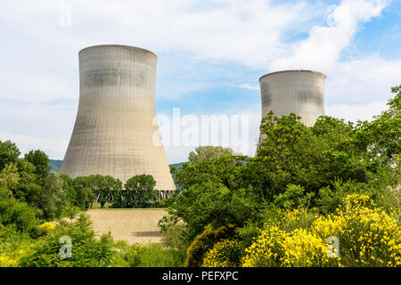 Deux tours de refroidissement à tirage naturel d'une centrale nucléaire libérant des nuages de vapeur d'eau au milieu de la campagne avec un champ labouré dans le Banque D'Images