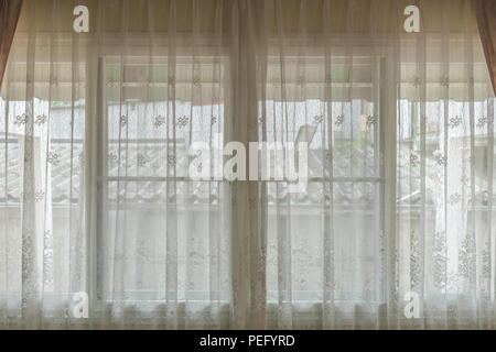 Rideau beige transparent et windows pour l'intérieur de la décoration. La lumière peut briller à travers elle. Banque D'Images