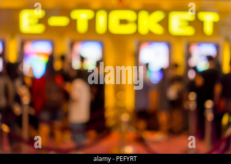 Flou abstrait les gens d'acheter de billet de cinéma e-ticket machine vente en face du théâtre Banque D'Images