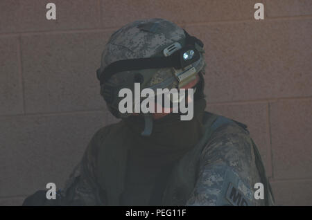 Un soldat de la Police militaire, avec l'Oregon Army National Guard's Brigade 116e Bataillon des troupes spéciales, montres et attend les instructions de son équipe au cours de la formation, le 17 août, au Centre National d'entraînement, Fort Irwin, en Californie Les parlementaires formés sur l'entrée de chambre de compensation, et la sécurisation. Ils ont également mené sur la formation au niveau local, les partenaires nationaux et l'évacuation médicale. (Photo par le Sgt. Anita VanderMolen, Mobile 115e Détachement des affaires publiques, de l'Oregon Army National Guard) Banque D'Images