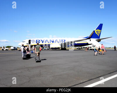 Les passagers à pied à travers l'aire de trafic vers leur vol de retour sur un avion de Ryanair Banque D'Images