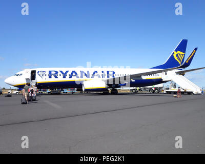 Les passagers à pied à travers l'aire de trafic vers leur vol de retour sur un avion de Ryanair Banque D'Images