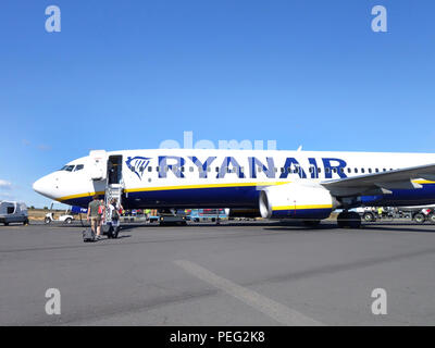 Les passagers à pied à travers l'aire de trafic vers leur vol de retour sur un avion de Ryanair Banque D'Images