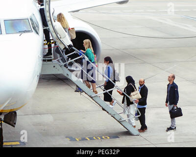 Close up of plane fenêtre du cockpit et les étapes en tant que passagers climbing steps up et sur leur vol sur le tarmac de l'Aéroport International de Manchester, Royaume-Uni Banque D'Images