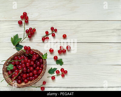 Grand frais et baies de groseille rouge sont dans un panier en osier sur un fond de bois sont en plongée des close-up Banque D'Images