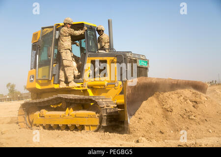 Des soldats américains affectés à la 1313th compagnie du génie, 113e bataillon du génie, de la Garde nationale de l'Indiana, et 5e Escadron, 73e Régiment de cavalerie, 3e Brigade Combat Team, 82e Division aéroportée, les ingénieurs de l'armée iraquienne enseigner comment utiliser un bulldozer au cours de formation de conducteur d'équipement lourd au Camp Taji, Iraq, 10 août 2015. Cette formation vous aidera à permettre aux forces de sécurité iraquiennes prennent l'initiative de l'ingénieur critique des tâches telles que la construction de bermes, creuser des positions de combat, et la réparation d'aviation. La formation à l renforcer les capacités des partenaires nationaux fait partie intégrante de la Force opérationnelle interarmées - pupitre Banque D'Images