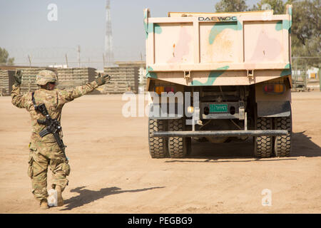 Le sergent de l'armée américaine. Joe Windle, affecté à la 1313th compagnie du génie, 113e bataillon du génie, de la Garde nationale de l'Indiana, des guides d'un camion à benne au cours de formation de conducteur d'équipement lourd au Camp Taji, Iraq, 10 août 2015. Cette formation vous aidera à permettre aux forces de sécurité irakiennes à prendre l'initiative de l'ingénieur critique des tâches telles que la construction de bermes, creuser des positions de combat, et la réparation d'aviation. La formation à l renforcer les capacités des partenaires nationaux fait partie intégrante de la Force opérationnelle interarmées - Fonctionnement du résoudre inhérent effort multinational pour former le personnel de l'ISF à l'encontre de l'État islamique d'Iraq et t Banque D'Images