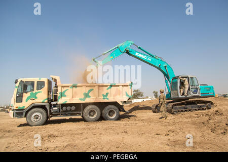 Les ingénieurs de l'armée iraquienne apprendre à utiliser une pelle hydraulique pour remplir un camion-benne au cours de formation de conducteur d'équipement lourd au Camp Taji, Iraq, 10 août 2015. Cette formation permettra aux forces de sécurité irakiennes à prendre l'initiative de l'ingénieur critique des tâches telles que la construction de bermes, creuser des positions de combat, et la réparation d'aviation. La formation à l renforcer les capacités des partenaires nationaux fait partie intégrante de la Force opérationnelle interarmées - Fonctionnement du résoudre inhérent effort multinational pour former le personnel de l'ISF à l'encontre de l'État islamique d'Irak et du Levant. (U.S. Photo de l'armée par le Sgt. Charles M. Bailey/libérés) Banque D'Images