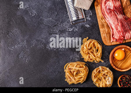 Ingrédients pour les pâtes à la Carbonara sur fond sombre, vue du dessus. Banque D'Images