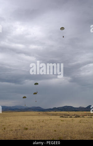 Formation parachutée cargaisons tomber au sol après avoir été largué d'un avion de transport C-130 Hercules affecté à la 120e Airlift Wing de la Garde nationale aérienne du Montana le 12 août 2015. L'avion prend part à un exercice laissant tomber le fer de lance du fret drop site situé à l'ouest de Toston, au Montana (Montana Air National Guard photo par le conseiller-maître Sgt. Eric Peterson/libérés) Banque D'Images