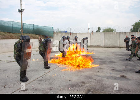 Les instructeurs de l'armée portugaise mènent une formation sur la phobie du cocktail Molotov pour une rotation de soldats hongrois du 5e Bocskai Istvan, affecté au groupement tactique multinational-East au Camp Slim Lines, au Kosovo, le 12 août 2015. La formation fait partie de la mission de soutien de la paix de l’OTAN, qui teste la capacité des soldats à réagir aux risques d’incendie, aux situations de foules et de contrôle des émeutes, et assure la disponibilité opérationnelle et la sécurité dans les missions du poste de commandement avancé. Banque D'Images