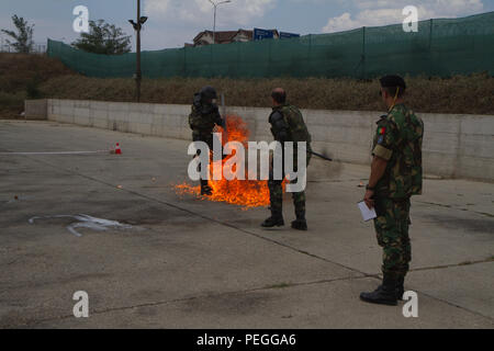 Au cours de l'entraînement à la phobie du feu au Camp Slim Lines, au Kosovo, des instructeurs de l'armée portugaise supervisent les soldats hongrois du 5e Bocskai Istvan affectés au MNBG-E. L’exercice comprend l’exposition à un cocktail Molotov, des essais de réaction, la gestion de la foule et des émeutes, des procédures de sécurité et la préparation opérationnelle dans le cadre de la mission de soutien de la paix de l’OTAN et des missions du poste de commandement avancé le 12 août 2015. Banque D'Images