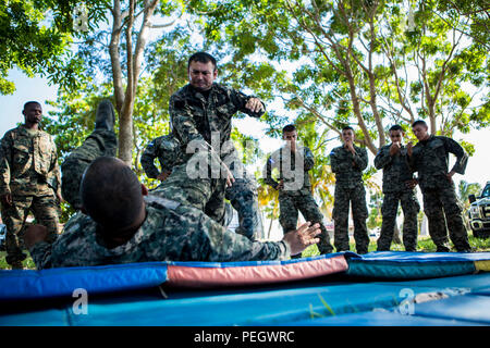 Les marines du Honduras une épaule pratique technique mélanger tout en participant au programme d'arts martiaux du Honduras à Naval Base Puerto Castilla, Honduras, 17 août 2015. Les Marines américains avec la coopération de sécurité maritime à des fins spéciales, Team-Honduras Groupe Force-Southern air-sol d'un suivi de commande de l'événement. SCT-Honduras est actuellement déployé dans le cadre de l'SPMAGTF-SC pour aider le Centro de Adiestramiento avec Naval la mise en œuvre d'un curriculum de formation pour créer un programme marin du Honduras. (U.S. Marine Corps Photo par le Cpl. Katelyn Hunter/relâché). Banque D'Images