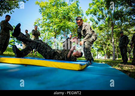 Les marines du Honduras une épaule pratique technique mélanger tout en participant au programme d'arts martiaux du Honduras à Naval Base Puerto Castilla, Honduras, 17 août 2015. Les Marines américains avec la coopération de sécurité maritime à des fins spéciales, Team-Honduras Groupe Force-Southern air-sol d'un suivi de commande de l'événement. SCT-Honduras est actuellement déployé dans le cadre de l'SPMAGTF-SC pour aider le Centro de Adiestramiento avec Naval la mise en œuvre d'un curriculum de formation pour créer un programme marin du Honduras. (U.S. Marine Corps Photo par le Cpl. Katelyn Hunter/libérés) Banque D'Images