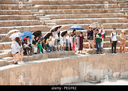 Groupe de touristes asiatiques à l'écoute de leurs guides sur les marches de l'amphithéâtre, Ephèse, Izmir, Turquie Banque D'Images