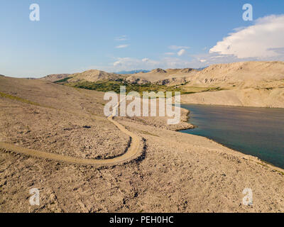 Vue aérienne d'une route sinueuse qui longe la côte croate, chemin de terre, près de l'île de Pag Rucica plage à Petrcane. Wild et non contaminée Banque D'Images