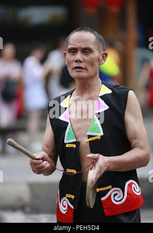 Les Griffin, dans la province de Hunan. Août 15, 2018. Artiste folklorique Ding Xinchun effectue à Sanbanggu Xibu Street, un endroit pittoresque dans le district de Wulingyuan de Zhangjiajie City, province du Hunan en Chine centrale, 15 août 2018. Sanbanggu est un spectacle traditionnel local art qui allie la musique, l'acrobatie et performance vocale. Credit : Wu Yongbing/Xinhua/Alamy Live News Banque D'Images