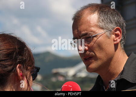 Gênes, Italie. Août 15, 2018. Fireman Emanuele Gissi répond aux questions des journalistes. Un jour après l'effondrement de l'autoroute pont Morandi (arrière-plan), il est toujours recherché pour les survivants dans les ruines énormes. Credit : Fabian Nitschmann/dpa/Alamy Live News Banque D'Images