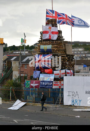 Londonderry, en Irlande du Nord. 11 août 2018. Feu de controverse. Un grand feu controversée a été érigé sur un site à l'abandon dans le Bogside, à Londonderry. Drapeaux de l'union des couronnes de coquelicots, et Armée britannique drapeaux régimentaires ont été mis sur le bûcher par les jeunes nationalistes. Un feu est traditionnellement brûlé dans la région le 15 août. ©George Sweeney / Alamy Live News Banque D'Images