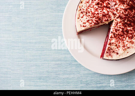 Tranche de gâteau de velours rouge sur fond bleu. Vue d'en haut. Copyspace Banque D'Images