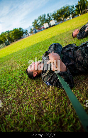 Un marin du Honduras s'étend après une session d'entraînement physique à Naval Base Puerto Castilla, le Honduras, le 13 août 2015. Les Marines américains avec la coopération de sécurité maritime à des fins spéciales, Team-Honduras Groupe Force-Southern air-sol La commande a également participé à la session. SCT-Honduras est actuellement déployé dans le cadre de l'SPMAGTF-SC pour aider le Centro de Adiestramiento avec Naval la mise en œuvre d'un curriculum de formation pour créer un programme marin du Honduras. (U.S. Marine Corps Photo par le Cpl. Katelyn Hunter/libérés) Banque D'Images