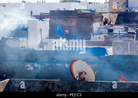 Toits avec antennes paraboliques et de la fumée des cheminées dans la médina d'Essaouira au Maroc Banque D'Images