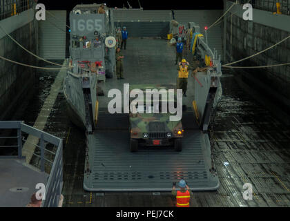 CAMP PENDLETON, en Californie (déc. 4, 2015) - marins et Marines mener une grande mobilité de véhicule à roues (HMMWV) à charger sur un bateau de débarquement de l'utilité (LCU) au cours des opérations à bord de pont et quai de transport amphibie USS Somerset (LPD 25), dans le cadre de l'exercice 2016 Chevalier d'acier. Chevalier d'acier est un exercice dirigé par 1 Division de marines qui permet à l'équipe de fonctionner en Navy-Marine réaliste un environnement interarmes pour acquérir des ensembles de compétences nécessaires pour fonctionner en tant qu'entièrement capable Maritime Aérien Au sol Groupe de travail. (U.S. Photo par marine Spécialiste de la communication de masse 1re classe Vladimir Ramos/Relea Banque D'Images