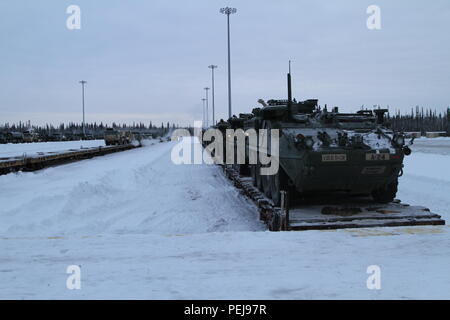 Strykers et autres véhicules d'attendre d'être chassés de voitures de train à Fort Wainwright, Alaska, le 9 décembre 2015. Le retour des véhicules signale la fin de la mission les voies du Pacifique au Japon et en Corée. Banque D'Images