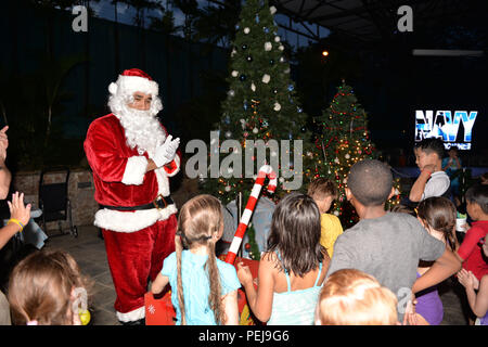 Singapour (31 déc. 4, 2015) - Santa Claus, joué par le lieutenant Cmdr. Edward Cruz Matos, de sept destroyers (COMDESRON 7) applaudit à la foule après l'éclairage des arbres de Noël au cours de l'assemblée annuelle de la région de la marine de Singapour Centre d'éclairage de l'arbre de Noël, Spectacle le 4 décembre 2015. L'événement a rassemblé plus de 150 membres du service militaire, les civils de la défense et les familles. L'événement était organisé par le moral de la société népalaise, de bien-être et de loisirs et les diverses activités d'art et d'artisanat, vendeurs de nourriture, et les bénévoles offrant des produits de boulangerie et les glaces boissons au chocolat et plus encore. En outre, le livre pour enfants gratuit Banque D'Images