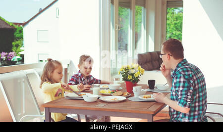 Happy Family having fun pendant le petit-déjeuner sur la grande terrasse à la maison Banque D'Images