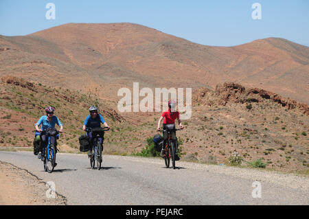 Trois coureurs arrivent à la crête d'une colline dans l'Anti Atlas au Maroc Banque D'Images