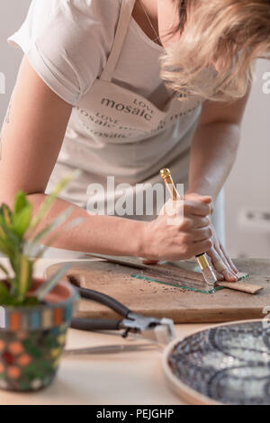 Feuilles à découper l'artiste du vitrail en petits carrés de mosaïque. Close-up Banque D'Images