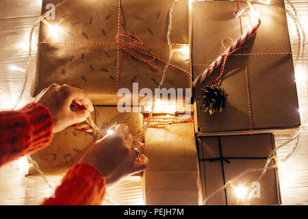 Moments magiques de noël. mains dans christmas lights en fête soirée prix en vertu de l'arbre dans l'éclairage, vue d'en haut. L'espace pour texte. girl Banque D'Images