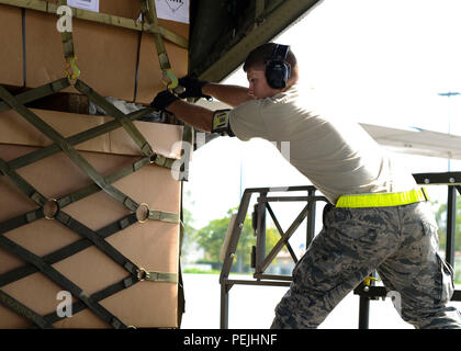 U.S. Air Force d'un membre de la 1re classe Joseph Coltson, 724ème escadron de la mobilité de l'air Spécialiste des services d'avions cargo, tire d'un C-130 Hercules Super sur un transporteur de conteneurs, le 28 août 2015 à la base aérienne d'Aviano, en Italie. À partir de la 724ème aviateurs AMS peut décharger immédiatement sur la piste de l'équipement pour les palettes peuvent être renvoyés à l'avion-cargo. (U.S. Photo de l'Armée de l'air par la Haute Airman Austin Harvill/libérés) Banque D'Images