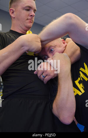 Le sergent-major de l'armée. Mitchel Havard, un recruteur de College Station, Texas, tente de sortir d'un headlock alors que le désarmement de l'Armée Le sergent. Timothy pont, un autre recruteur de College Station, au cours d'une classe de formation d'auto-défense dans un sport d'arts martiaux à College Station, 14 août 2015. Le propriétaire et l'instructeur, Maître Renee Nolte, se sont portés volontaires pour enseigner les différentes méthodes de recrutement non armés de légitime défense contre armes diverses, d'inclure des pistolets et des couteaux. Avec les attaques à Chattanooga, Tennessee, Nolte voulait s'assurer que les recruteurs sont capables de se défendre si sw Banque D'Images