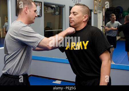 Le sergent-major de l'armée. Aric Zern, un recruteur de College Station, Texas, tandis que l'Armée frappe pratiques désarmer le Sgt. 1re classe Javier Torres, commandant de station pour le bureau de recrutement de College Station, au cours d'une classe de formation d'auto-défense dans un sport d'arts martiaux à College Station, 14 août 2015. Le propriétaire et l'instructeur, Maître Renee Nolte, se sont portés volontaires pour enseigner les différentes méthodes de recrutement non armés de légitime défense contre armes diverses, d'inclure des pistolets et des couteaux. Avec les attaques à Chattanooga, Tennessee, Nolte voulait s'assurer que les recruteurs sont en mesure de se défendre eux-mêmes Banque D'Images