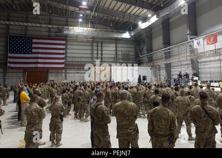 Des artistes musicaux apparaissent sur scène lors d'un spectacle des United Service Organizations à la base aérienne de Bagram, en Afghanistan, diffusant de la musique live pour les militaires américains déployés pendant la saison des fêtes. Le programme de divertissement comprend plusieurs chanteurs et instrumentistes engageant un public militaire à l'intérieur d'un lieu de base. L’événement de l’USO fait partie des activités programmées sur le moral conçues pour soutenir le bien‑être des troupes pendant les opérations outre‑mer. Banque D'Images