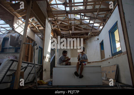 Les enfants sont assis à l'école endommagée à Falalop Island, Atoll Ulithi, États fédérés de Micronésie, le 7 décembre 2015. La plupart des installations d'éducation a été dévastée par le typhon Maysak en mars 2015. (U.S. Air Force photo par Yasuo Osakabe/libérés) Banque D'Images