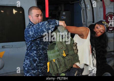 151208-N-RR852-030 JACKSONVILLE, Floride (31 déc. 8, 2015) - La survie de l'équipage 2e classe Equipmentman Kyle Coe, attaché à la 'Airwolves" de l'Escadron d'hélicoptères grève maritime (HSM) 40 contribue à la World Wrestling Entertainment (WWE) Diva Alicia Fox essayer sur l'équipement de l'équipage de l'air au cours d'une visite d'un hangar 40 HSM sur la station navale de Mayport (NS). WWE Superstars et Divas visité NS Mayport, Naval Air Station Jacksonville et Naval Submarine Base Kings Bay, dans le cadre de la 13e édition de la WWE hommage aux troupes. (U.S. Photo par marine Spécialiste de la communication de masse Bobby 1ère classe Northnagle/ publié) Banque D'Images