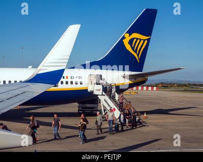 Les passagers de descendre et monter à bord d'un vol de la compagnie aérienne Ryanair de budget sur la piste à l'aéroport de Manchester England UK Banque D'Images