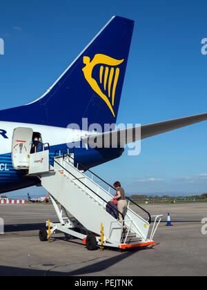 Les passagers de descendre et monter à bord d'un vol de la compagnie aérienne Ryanair de budget sur la piste à l'aéroport de Manchester England UK Banque D'Images