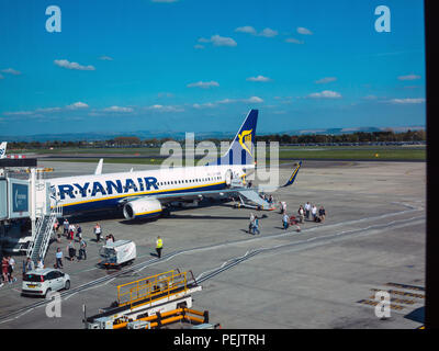 Les passagers de descendre et monter à bord d'un vol de la compagnie aérienne Ryanair de budget sur la piste à l'aéroport de Manchester England UK Banque D'Images